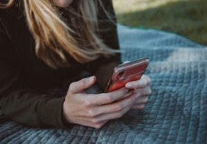 Oculusbanks owner sending an e-transfer from a mobile phone while outdoors at a park