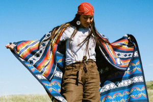 Indigenous woman with quilt wrapped around her shoulders